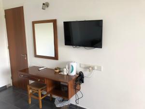 Lyso迪米特里天堂酒店的一间设有一张桌子的房间,墙上配有电视