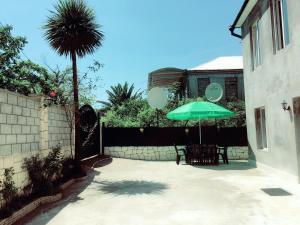 马钦加里Guest House Maxim的一个带桌子和遮阳伞的庭院