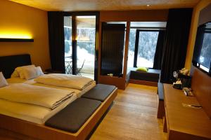 大格洛克纳山麓卡尔斯格拉多纳山木屋度假酒店的一间卧室配有两张床和电视。