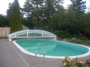 穆耶龙·勒卡普蒂夫Le Clos Sainte Lea的一座游泳池,上面有一座玻璃桥
