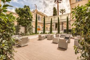 罗马自由精品酒店的一个带椅子的庭院和一座建筑
