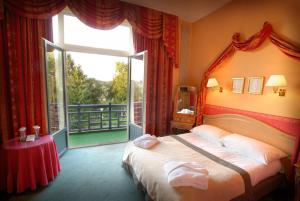 亨法尔马丁曼诺尔酒店的一间卧室设有一张床和一个大窗户