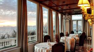 阿尔盖罗拉斯多洛娜斯温泉别墅酒店的用餐室设有桌子和大窗户
