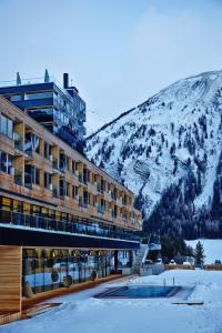 大格洛克纳山麓卡尔斯格拉多纳山木屋度假酒店的一座有雪覆盖的山地的酒店