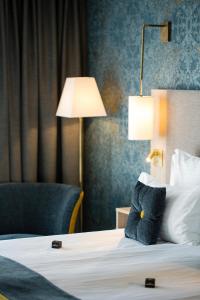 科尔马James Boutique Hôtel Colmar centre的酒店客房,配有带灯和椅子的床