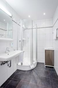 慕尼黑宁芬堡斯加罗斯兰蒙酒店的白色的浴室设有水槽和淋浴。