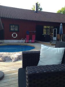 卡特琳娜霍尔姆Björnåsen Bear Hill的房屋前的一个带沙发和椅子的游泳池