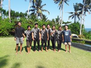 塞莱马德加努玛珍巴厘岛别墅酒店的一群年轻人在草地上摆上一张照片