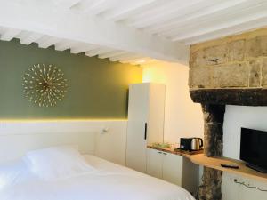 翁弗勒尔La Maison des Arts, Le Six的一间卧室配有一张床和一个石头壁炉