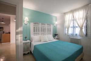 马蒂诺Al KamarTaj的卧室设有蓝色和白色的床和窗户。