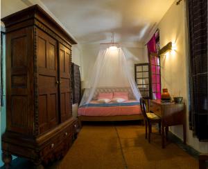 康提康提萨玛西中心酒店的一间卧室配有一张床、梳妆台和一张睡床。