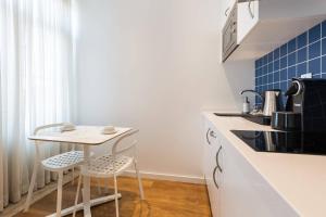 里斯本希亚多梦公寓的厨房配有小桌子和2把凳子