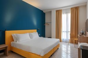 阿拉西奥日瓦酒店的一间卧室设有一张大床和蓝色的墙壁