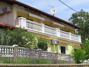 奥帕提亚Guesthouse Katarina的黄色和白色的房子,设有白色阳台