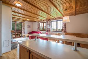 Ribnica na PohorjuApartmajsko naselje Ribniško Pohorje的一间厨房和客厅,配有木制天花板和桌子