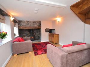 切达Red Rose Cottage的客厅设有两张沙发和一个壁炉