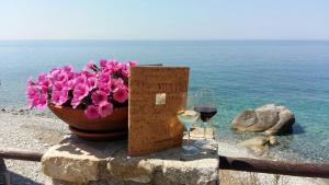 波蒙特Hotel Sardi的一瓶粉红色的鲜花和一杯葡萄酒