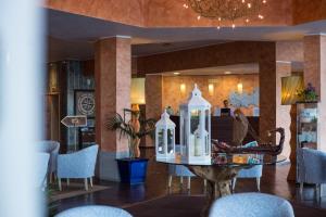 卡波利韦里TH Capoliveri - Grand Hotel Elba International的大堂配有桌椅和吊灯。