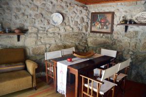 Viatodos卡萨卡瓦略农家乐的一间设有桌子和石墙的用餐室