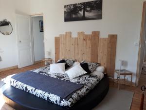 圣加蒂安代布瓦乐瓦尔提皮斯豪华帐篷的一间卧室配有一张大床和木制床头板