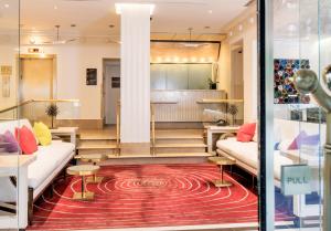 纽约70 Park Avenue Hotel的大堂的红色地毯上设有沙发和桌子