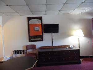 Tazewell塔兹韦尔汽车旅馆 的客房设有书桌和墙上的电视
