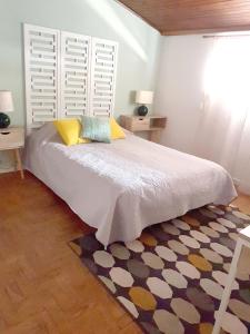 塞图巴尔Casa70的一间卧室配有一张带两张桌子和一扇窗户的床。