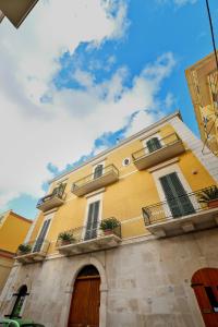 科拉托Le Stanze di Filippo Tandoi的黄色的建筑,设有窗户和阳台