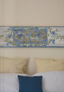 巴勒莫Casa Jolanda B&B的床上方墙上的画作,上面有枕头
