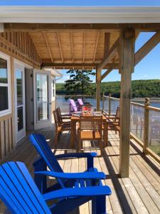Deep BrookStill Point Lodge的甲板配有蓝色的椅子和桌椅