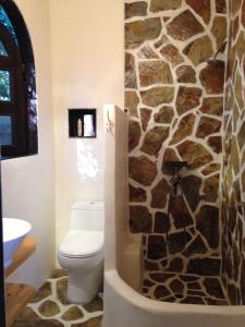 洛杉矶Under the Tuscan Sun Cottage in West Los Angeles的一间带卫生间和石墙的浴室