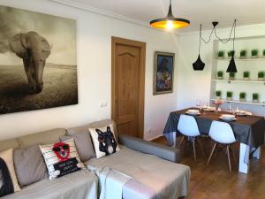 佐瑞奎Apartamento Ezcaray con Piscina的客厅配有沙发、桌子和大象绘画