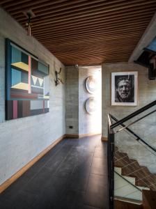 圣地亚哥Maison Italia 1029的走廊上设有楼梯,墙上挂有绘画作品