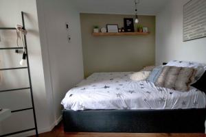 戈伊斯De Kade的一间卧室配有带白色床单和枕头的床。