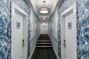 迈阿密海滩企鹅酒店的走廊设有蓝色和白色的墙壁和楼梯