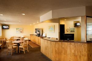 苏必利尔Superior Inn的餐厅设有酒吧、桌子和椅子