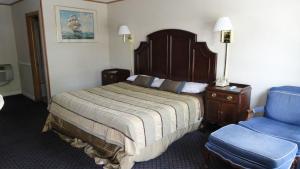 纽波特Harbor Base Inn的酒店客房,配有一张床和一张蓝色椅子