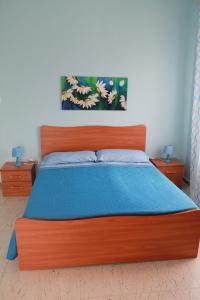 贝尔韦代雷Casa Michelina的一间卧室配有一张带蓝色毯子的木床