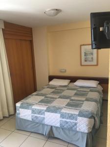 福塔莱萨FortalezAmar Hotel Praia Mansa的一间卧室配有一张带 ⁇ 子毯子的床