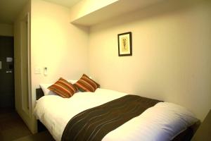 东松岛东松岛矢本最佳价值酒店 的一间卧室配有一张带两个枕头的床