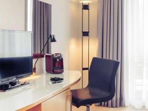 卡门美卡门乌纳旅馆的客房设有书桌、电视和椅子