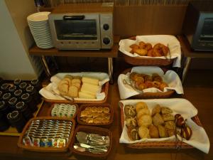 小松市格兰蒂亚小松机场路线客栈的一张桌子,上面放着几盘面包和糕点
