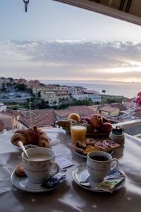 圣尼科拉阿尔切拉B&B Villa San Nicola的一张桌子,上面放着咖啡和糕点