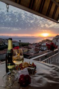 圣尼科拉阿尔切拉B&B Villa San Nicola的一张桌子上的一杯葡萄酒,享有日落美景