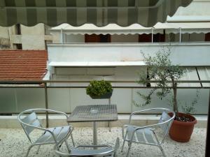 雅典萨皮恩酒店的庭院里设有两把椅子和一张桌子