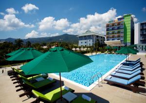 查汶苏梅岛垂直颜色酒店的一个带椅子和遮阳伞的游泳池以及酒店
