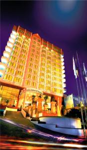 沙马林达瑞雅婆罗洲三马林达酒店的一座黄色的大建筑,前面有灯