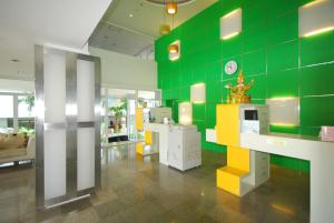 查汶苏梅岛垂直颜色酒店的一间设有绿色墙壁的客房,墙上挂着时钟