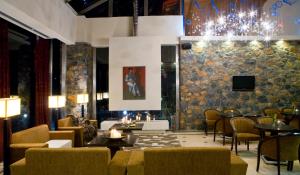 帕雷斯阿吉萨那Domotel Neve Mountain Resort的大堂设有桌椅和吊灯。