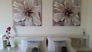 巴多利诺Cabà Holiday Bardolino Gritti的卧室配有两张墙上的照片和一张床